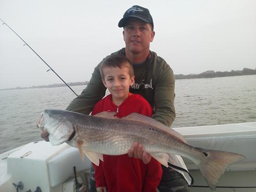 Fishing charter capt. Greg Verm with child holding his catch